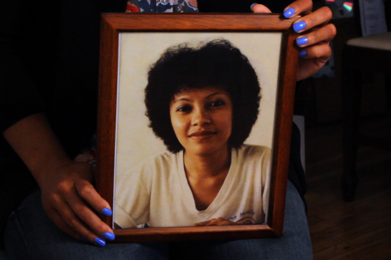 Paula holding a portrait of her mother.