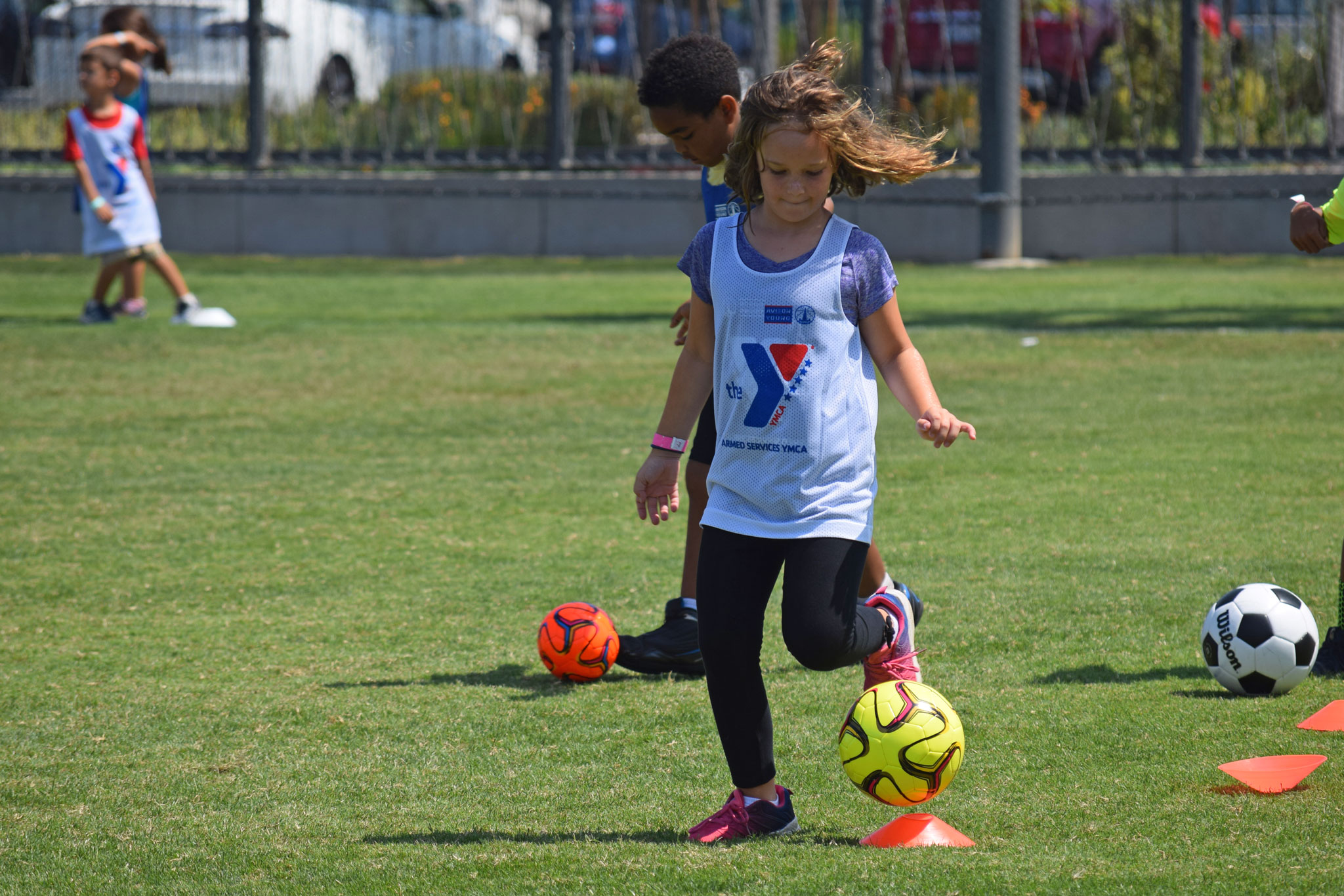 Girl playing soccer at Armed Services YMCA camp