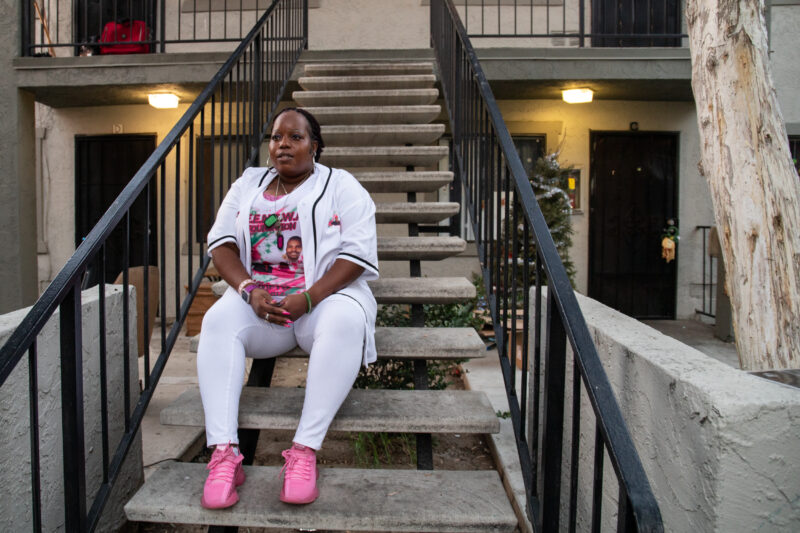 Essie Mae Horne sits on a set of stairs near her old aparment (bottom right) at Creekside Villas on Feb. 1, 2022. Horne’s husband Andre Mahan Sr. was murdered in their home back in 2006 when an unknown man entered the house and shot him. Horne, who was in her bedroom, found her husband gasping for air on their kitchen floor. This is the first time Horne has visited her old apartment since the shooting 16 years ago. / Photo by Adriana Heldiz