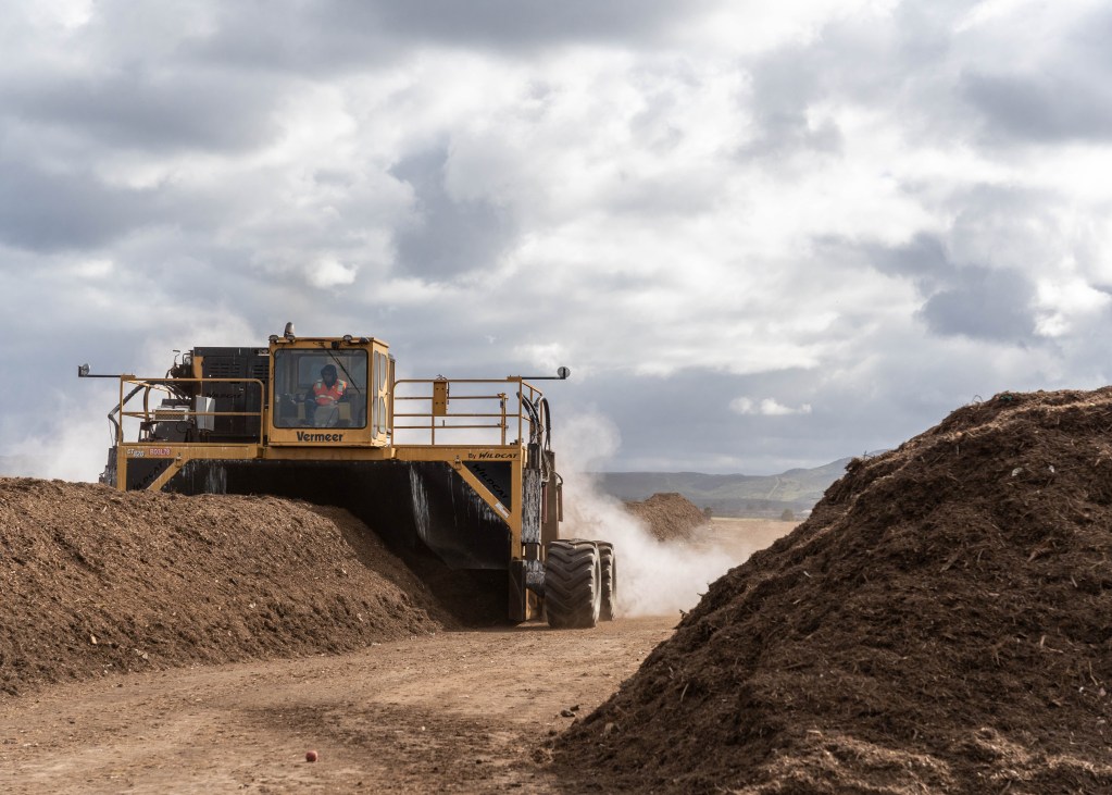 A Miramar Landfill employee drives a compost turner over a compost pile to oxygenate the waste on Feb. 22, 2022.
