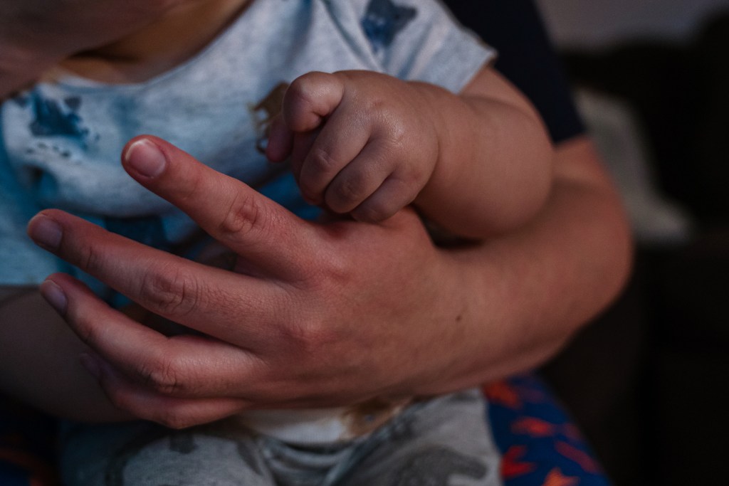 Sophia Rodriguez gives her 10-month-old son a bottle while he holds her finger in Chula Vista on March 8, 2022.