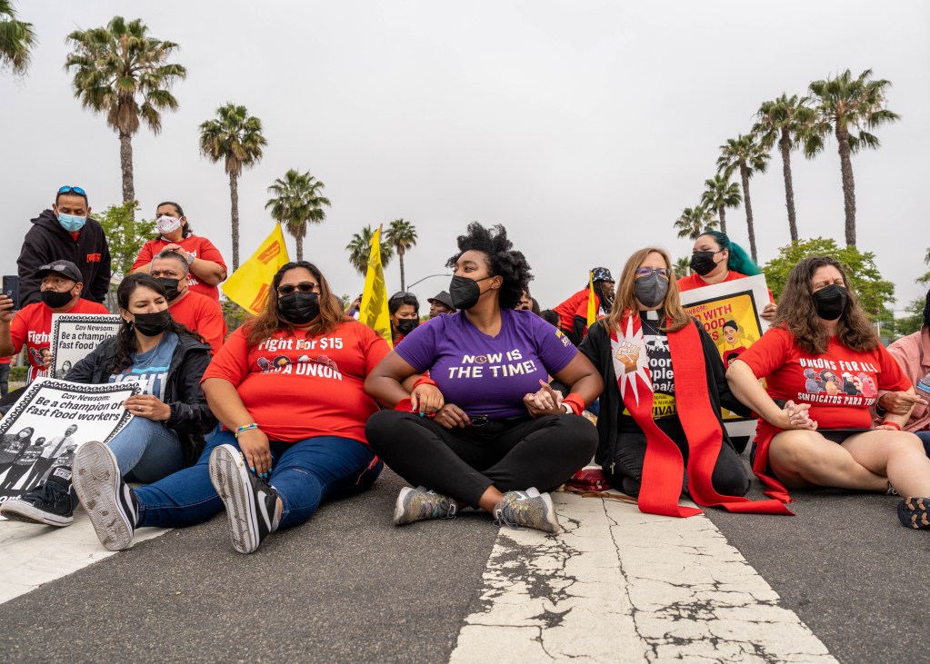 Crystal Irving, president of SEIU Local 221, joins fast food workers and activists to block traffic outside Jack in the Box headquarters on June 9, 2022. / Photo by Joe Orellana for Voice of San Diego