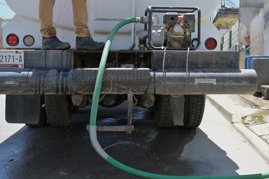 A water truck delivers water to a home on Friday, July 1, 2022. / Photo by Carlos A. Moreno for Voice of San Diego