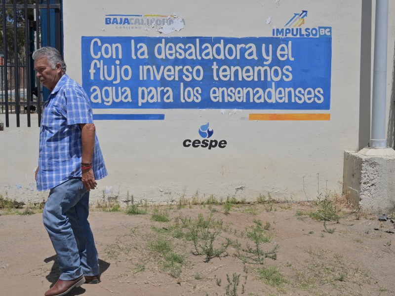 At CESPE main water desalination plant, where a representative passes along a mural that reads “With the desalination and inverse flow we have water for Ensenadenses.” / Photo by Carlos A. Moreno for Voice of San Diego