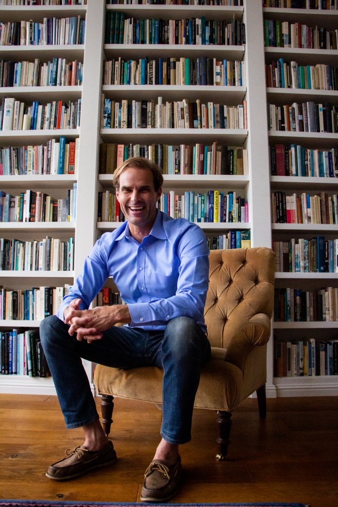 Cody Petterson sits in front of his vast book collection at his home in La Jolla, CA.