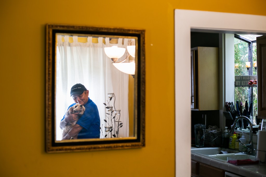 Godwin Higa, SDUSD board candidate, holds his dog Cookie in his home in San Diego, CA.