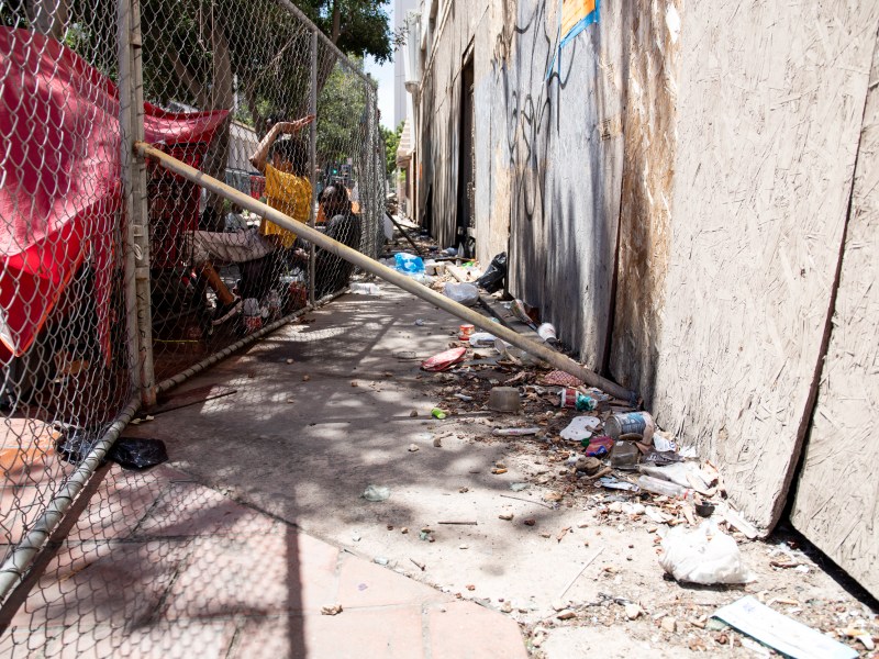 People staying in front of the California Theatre lean against a fence erected on C Street, directly in front of an open entrance to the building on Aug. 10, 2022. / Photo by Jakob McWhinney