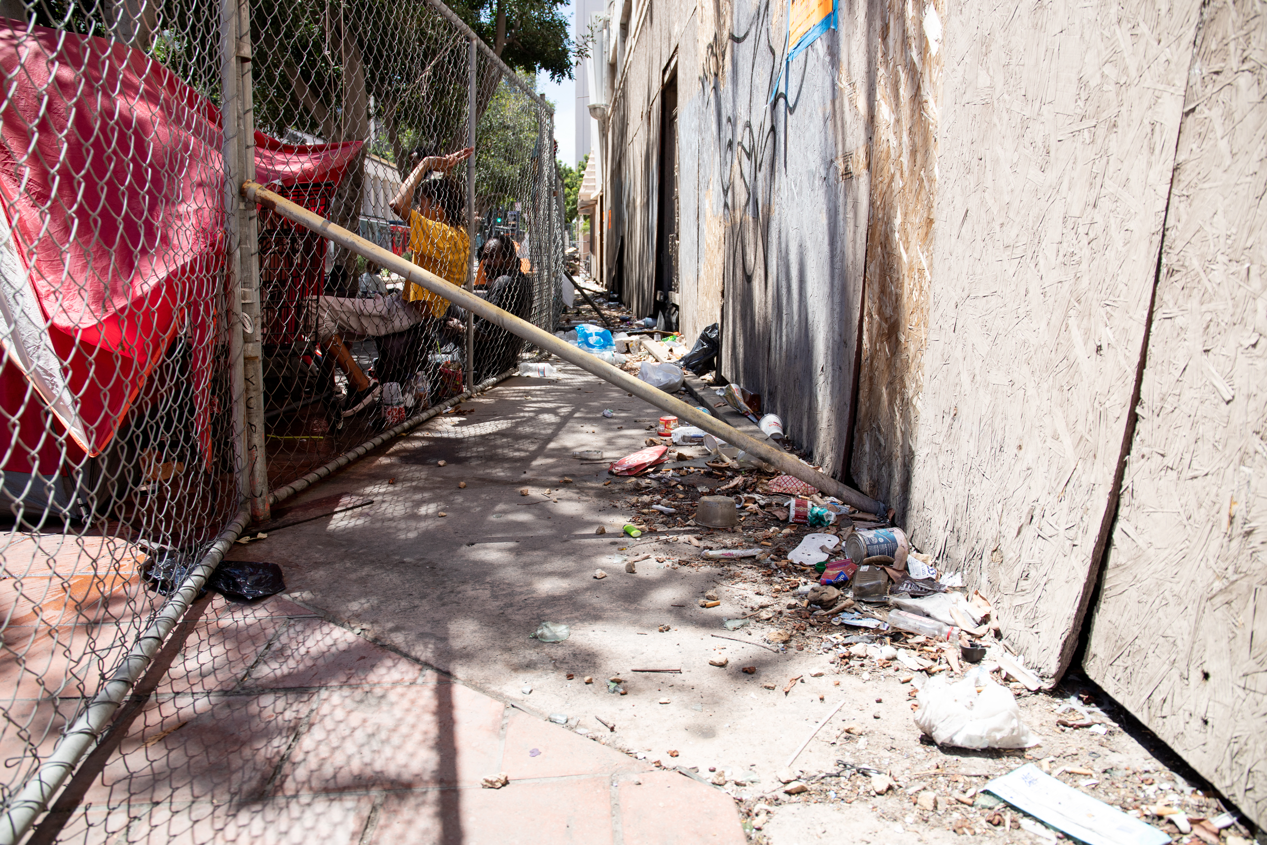 People staying in front of the California Theatre lean against a fence erected on C Street, directly in front of an open entrance to the building on Aug. 10, 2022. / Photo by Jakob McWhinney