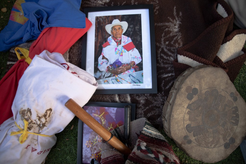 A photo of Marcelino Robles, a Huichol medicine man, lays among altar items. / Photo by Jakob McWhinney