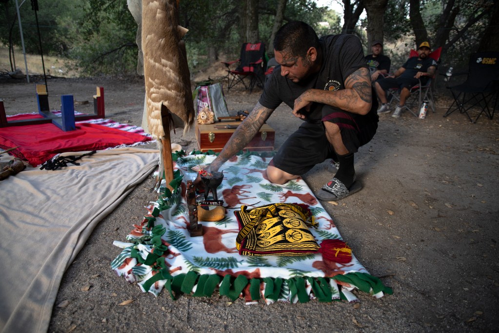 Mario Robles kneels before the altar. / Photo by Jakob McWhinney