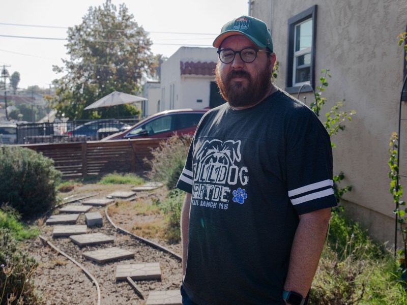 Alan Underwood, a music teacher, stands outside the City Heights house he and his wife purchased in 2018. / Photo by Jesse Marx