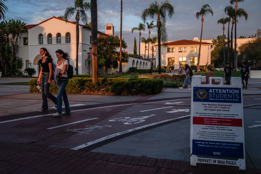 Students walk on campus near a sign from the San Diego State University police in the College Area on September 12, 2022.