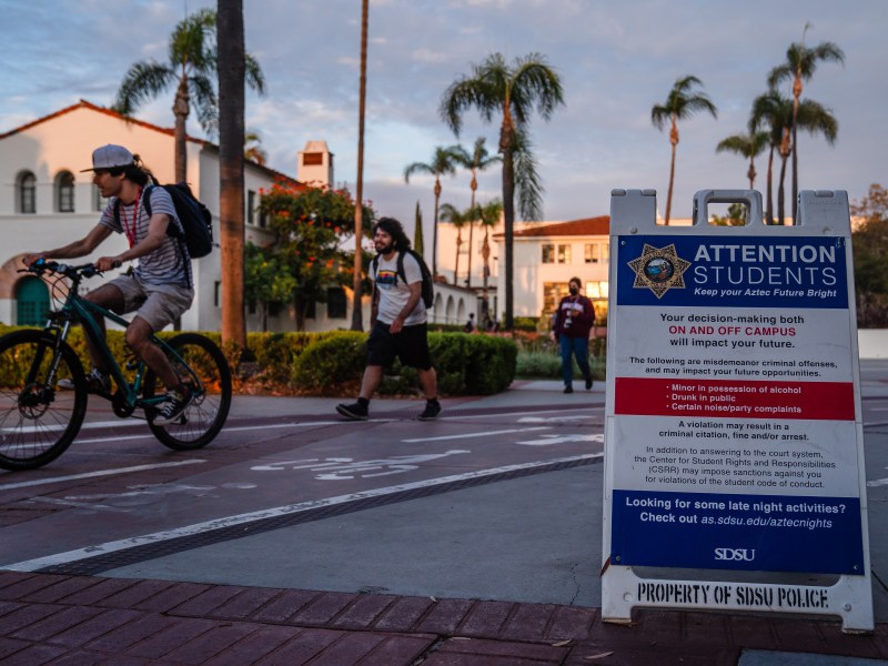 Students walk on campus near a sign from the San Diego State University police in the College Area on September 12, 2022.