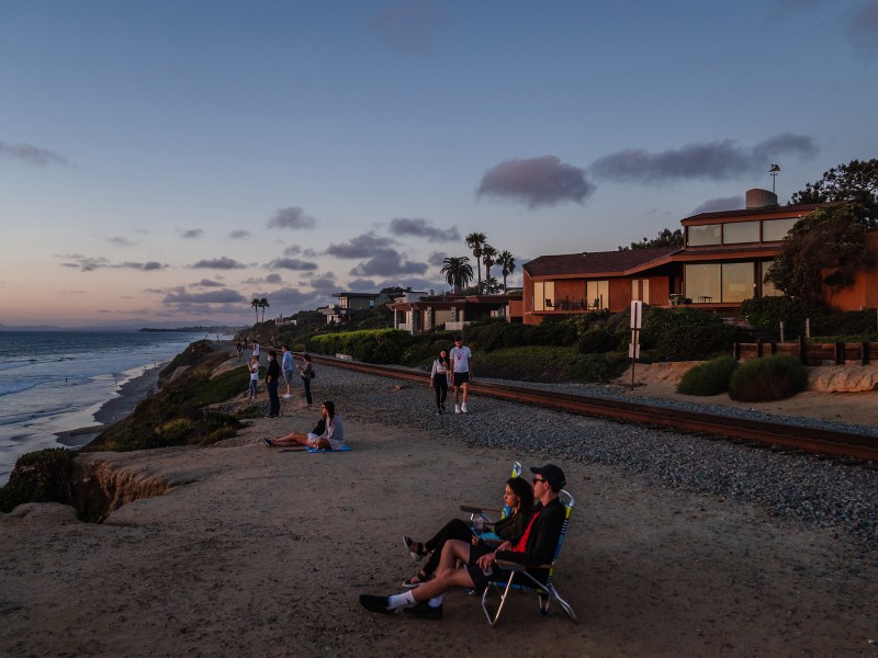 People watch the sunset near the train tracks in Del Mar on Sept.19, 2022.