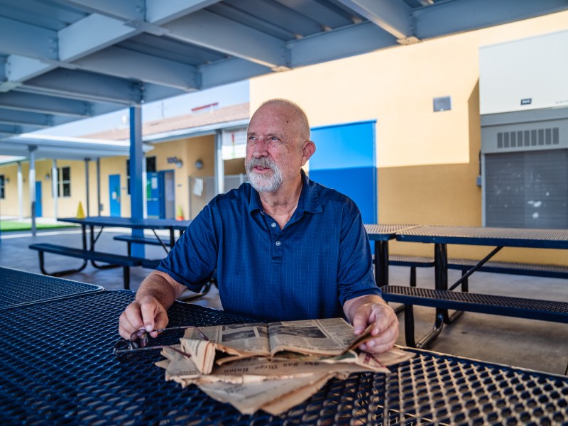 Jim Groth sits in front of newspapers from November 1978 from The San Diego Union and the Los Angeles Times taken at Harborside Elementary School in Chula Vista.