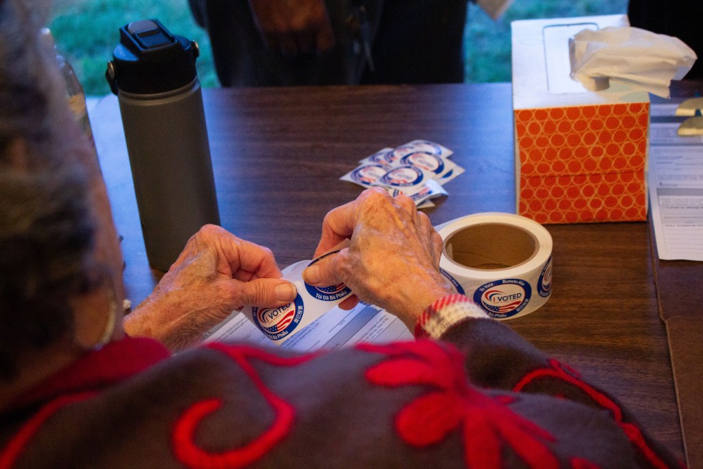 Poll worker Jan Williams separates “I Voted” stickers to distribute to residents who turn in their ballot at the Bay View Baptist Church in Chula Vista on Nov. 8. / Photo by Brittany Cruz-Fejeran for Voice of San Diego