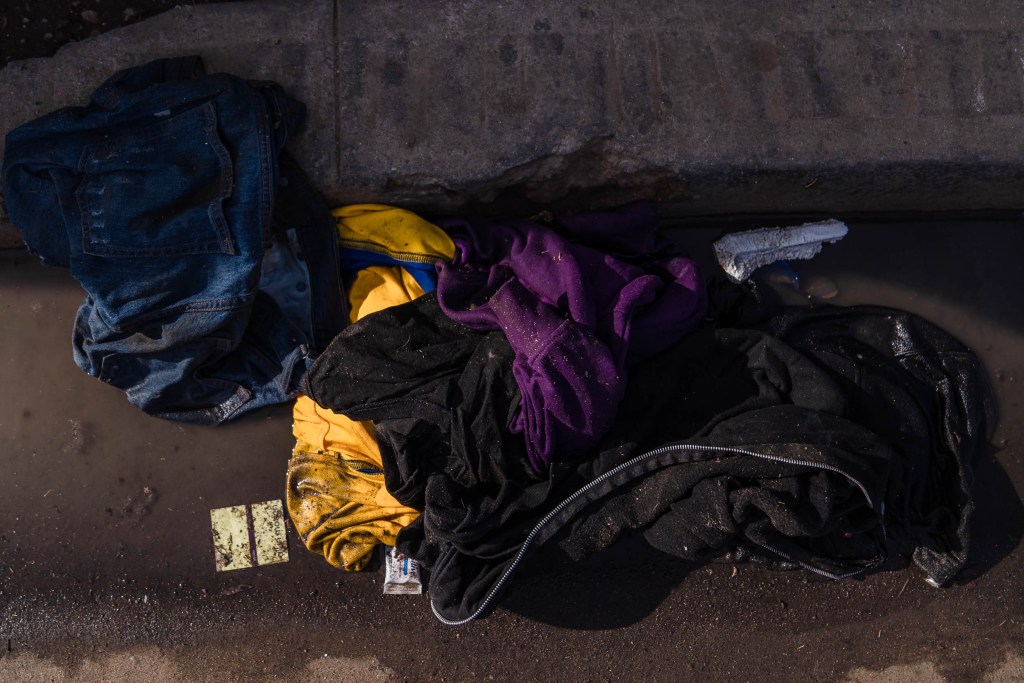 Clothes can be seen in a puddle near a homeless encampment in downtown on Nov. 11, 2022.