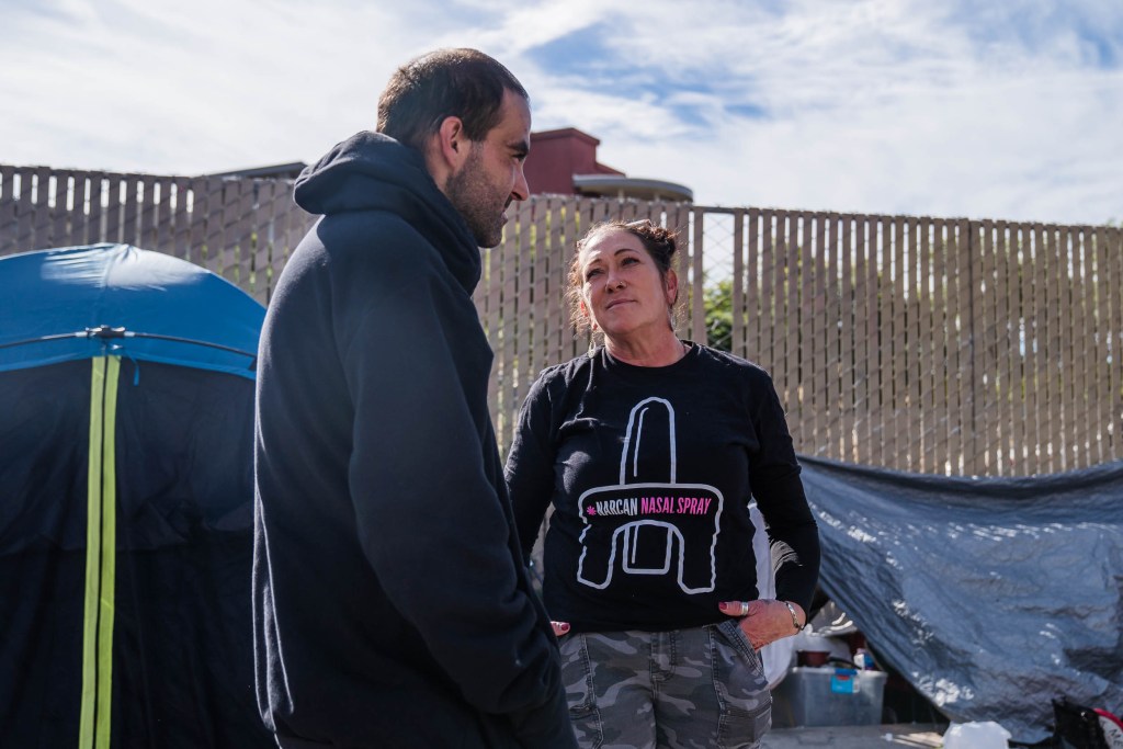 Tara Stamos-Buesig (right) from the Harm Reduction Coalition talks to David Amrani who is unhoused in downtown on Nov. 11, 2022.