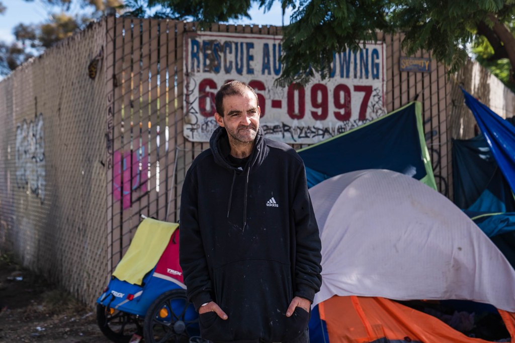 David Amrani, 36 years old from Maine stands near his tent in downtown on Nov. 11, 2022.