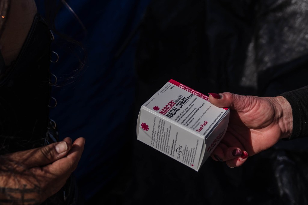 Tara Stamos-Buesig from the Harm Reduction Coalition hands out Narcan Nasal Spray to people living in a homeless encampment in downtown on Nov. 11, 2022.