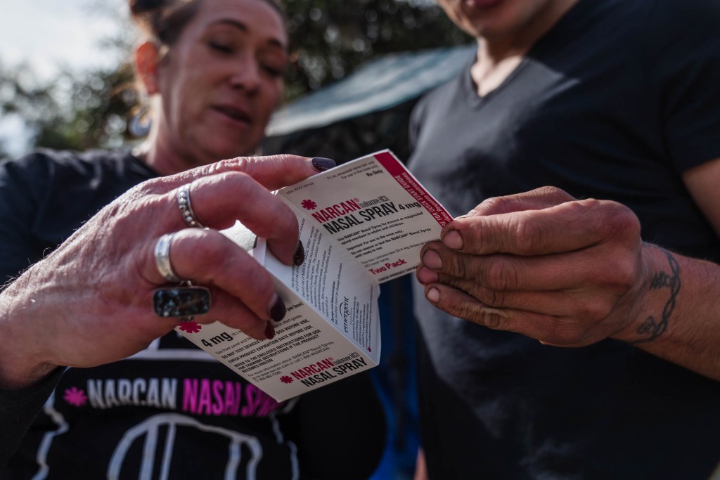 Tara Stamos-Buesig (right) from the Harm Reduction Coalition gives Narcan Nasal Spray to Victoria Secretos, 33 years old who is unhoused in downtown on Nov. 11, 2022.