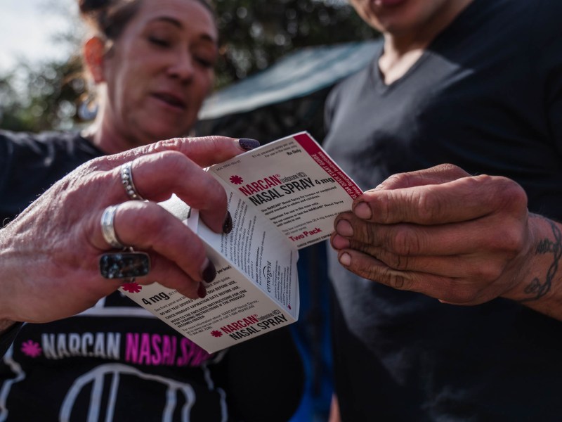 Tara Stamos-Buesig (right) from the Harm Reduction Coalition gives Narcan Nasal Spray to Victoria Secretos, 33 years old who is unhoused in downtown on Nov. 11, 2022.