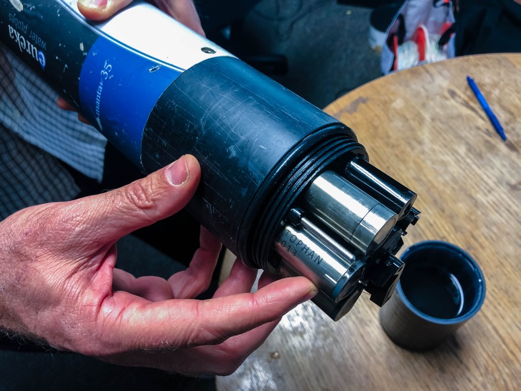 Trent Biggs, a watershed scientist at San Diego State University, points to a tryptophan sensor in a new real-time water quality instrument for the polluted Tijuana River. / MacKenzie Elmer