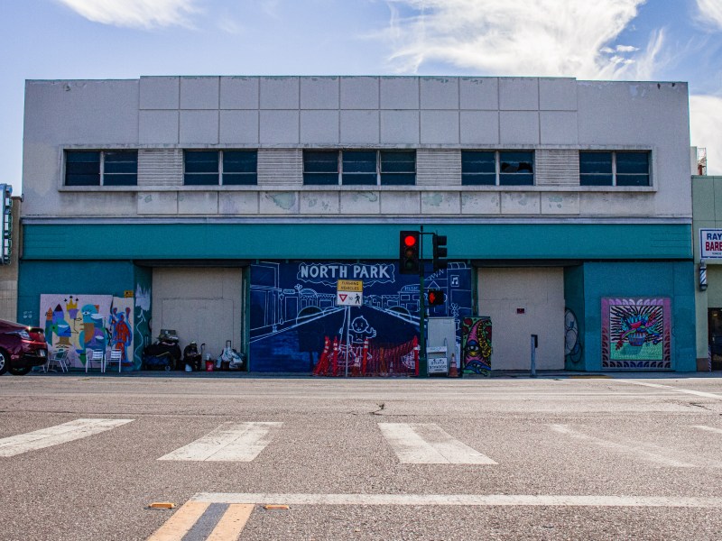 Murals cover the fading paint on an empty Woolworth building on Oct. 20, 2022, while construction continues on the sidewalk.