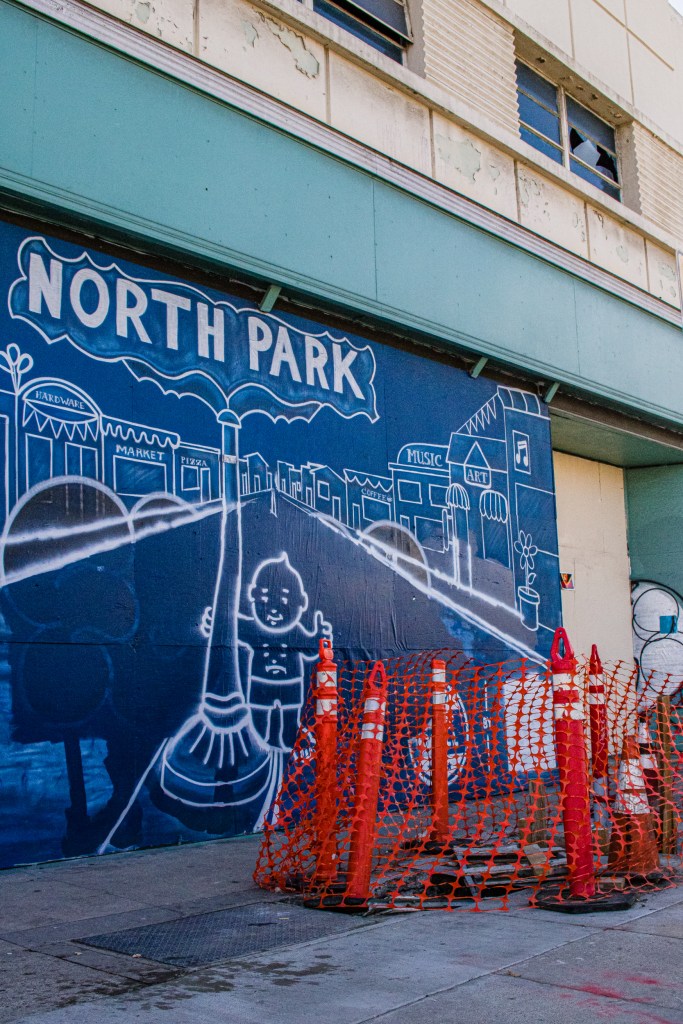 Murals cover the fading paint on an empty Woolworth building on Oct. 20, 2022, while construction continues on the sidewalk.