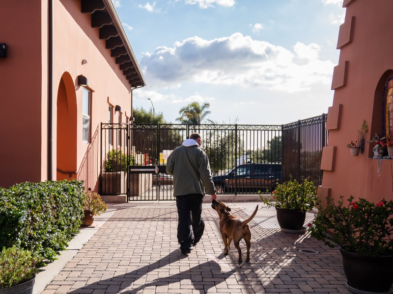 Dallin Mifflin walks with his dog Lita at La Posada de Guadalupe shelter in Carlsbad on Dec. 13, 2022.