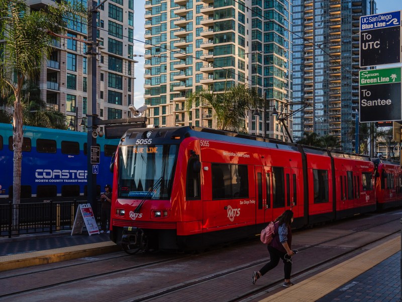 A woman walks across the trolley tracks at the Santa Fe Depot in downtown on Oct. 4, 2022.