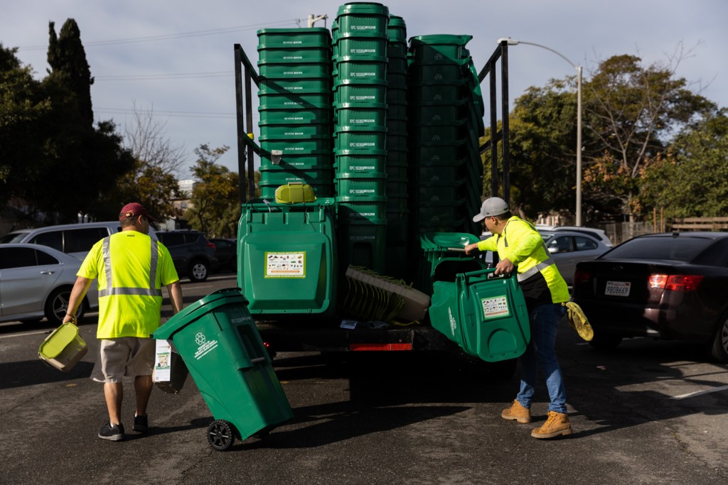 Contract workers assemble and deliver food waste bins in the Sherman Heights neighborhood on Jan. 11, 2023.