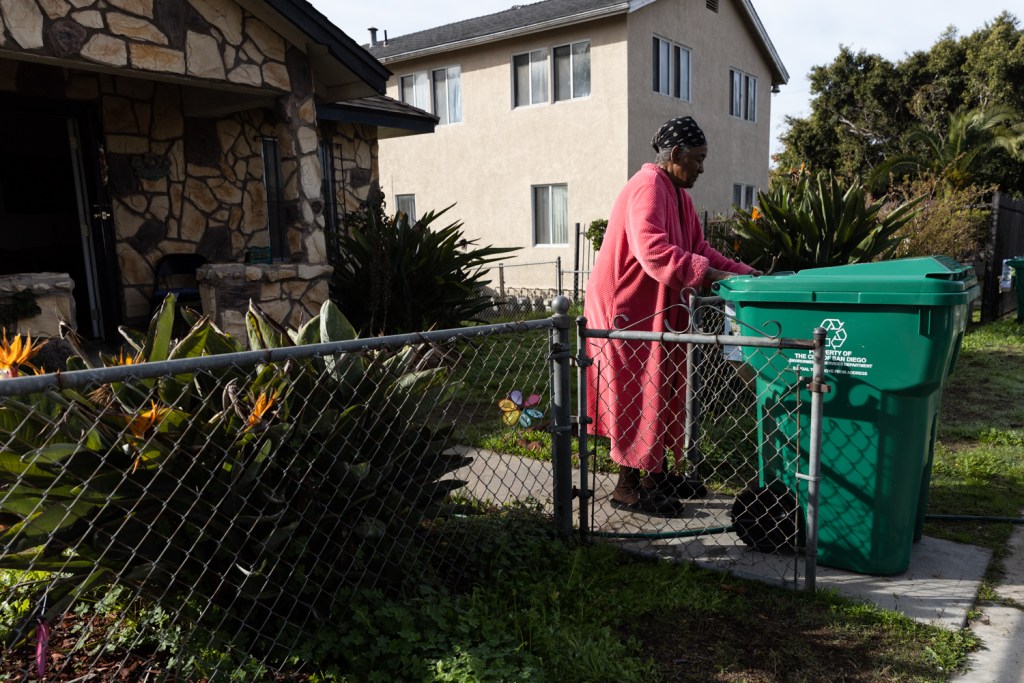 Norall Moore, who has lived in the Sherman Heights neighborhood since 1964, wheels in a new food waste bin into her front yard on Jan. 11, 2023.