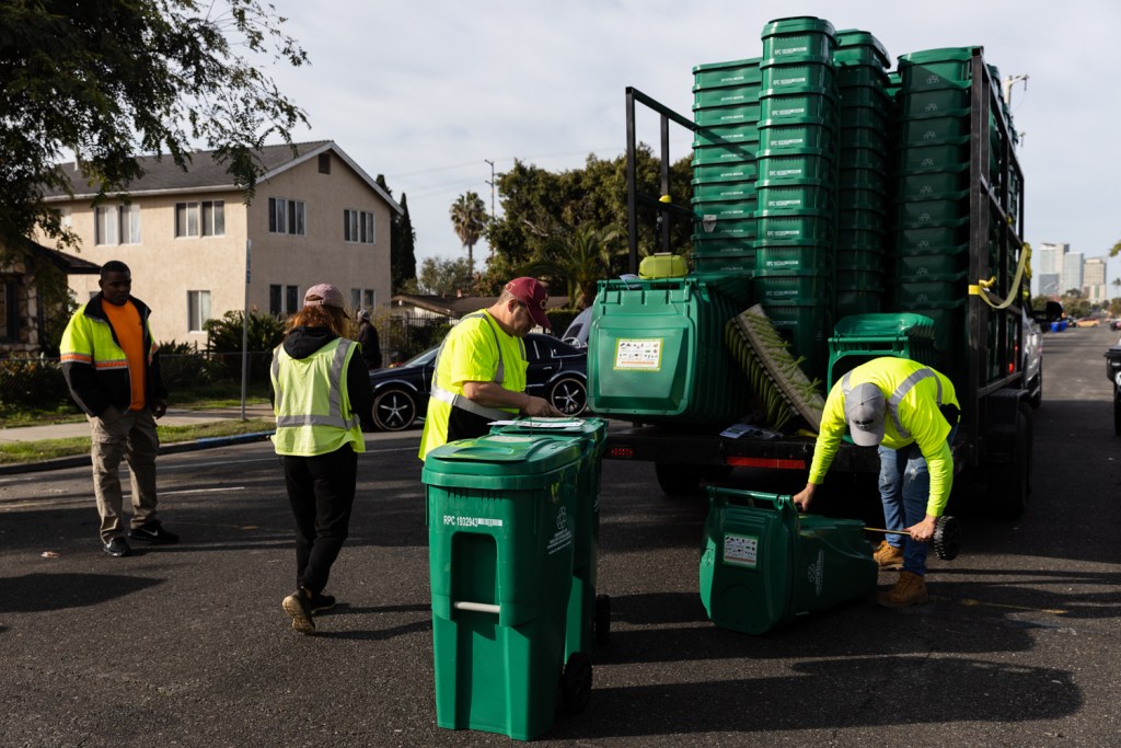 Contract workers assemble and deliver food waste bins in the Sherman Heights neighborhood on Jan. 11, 2023.