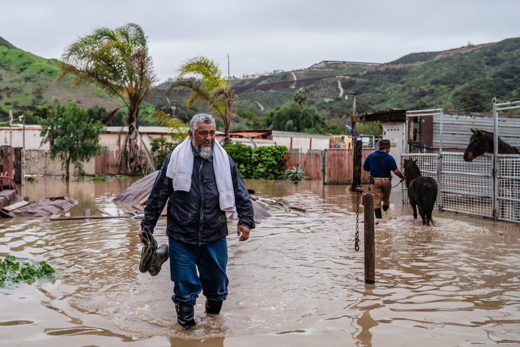 Carlos Moreno walks through a flooded Dresher Ranch in San Ysidro on Jan. 16, 2023.
