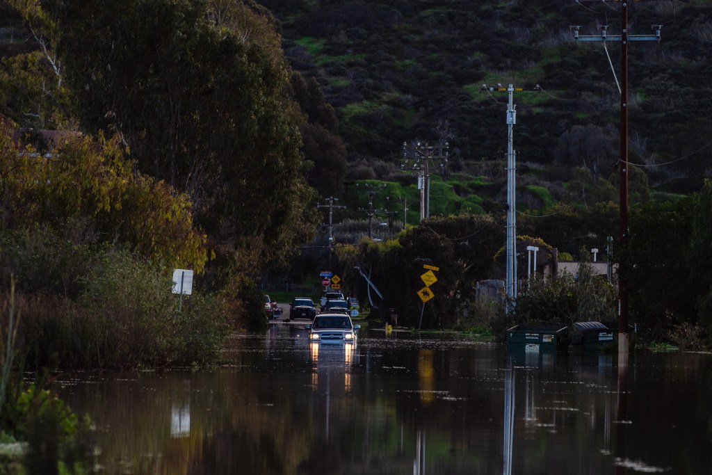 A car stuck in the water on Hollister Street in San Ysidro on Jan. 17, 2023.