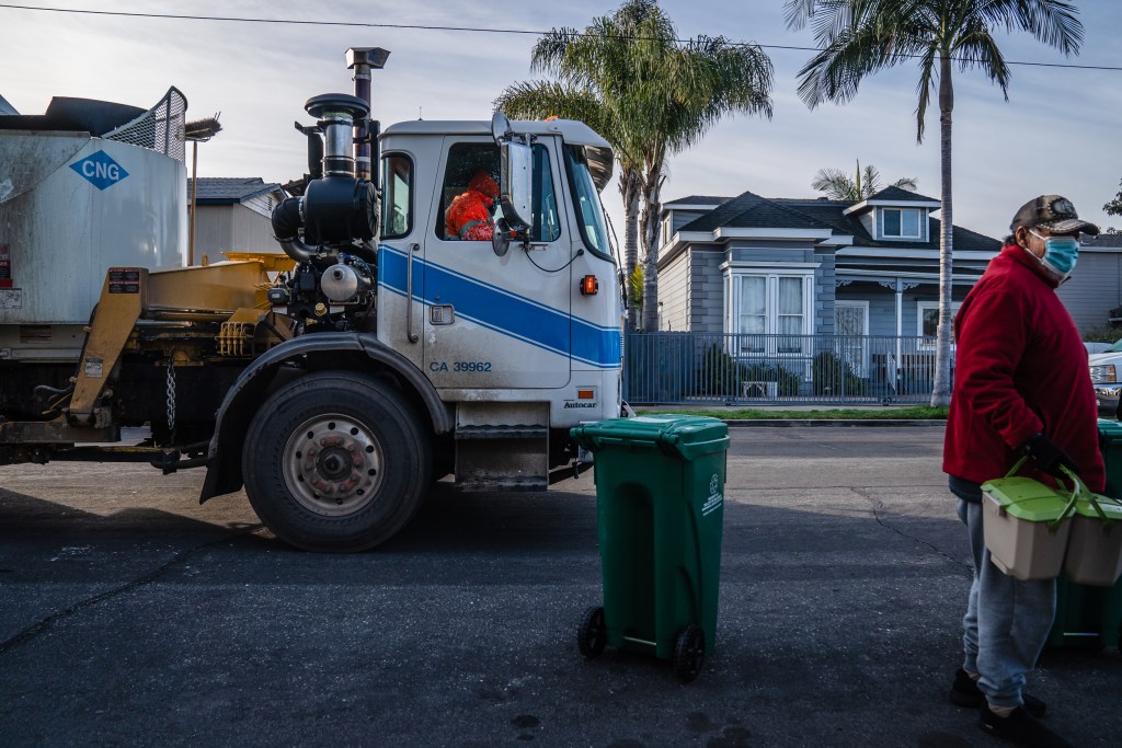 Julio Gomez stands near a new waste bin holding his kitchen pails in Grant Hill on Jan. 19, 2023.