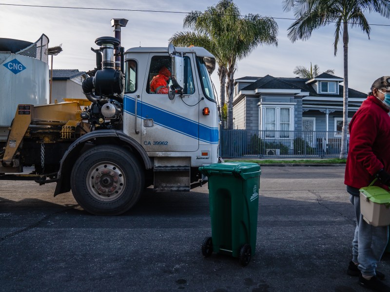 Julio Gomez stands near a new waste bin holding his kitchen pails in Grant Hill on Jan. 19, 2023.