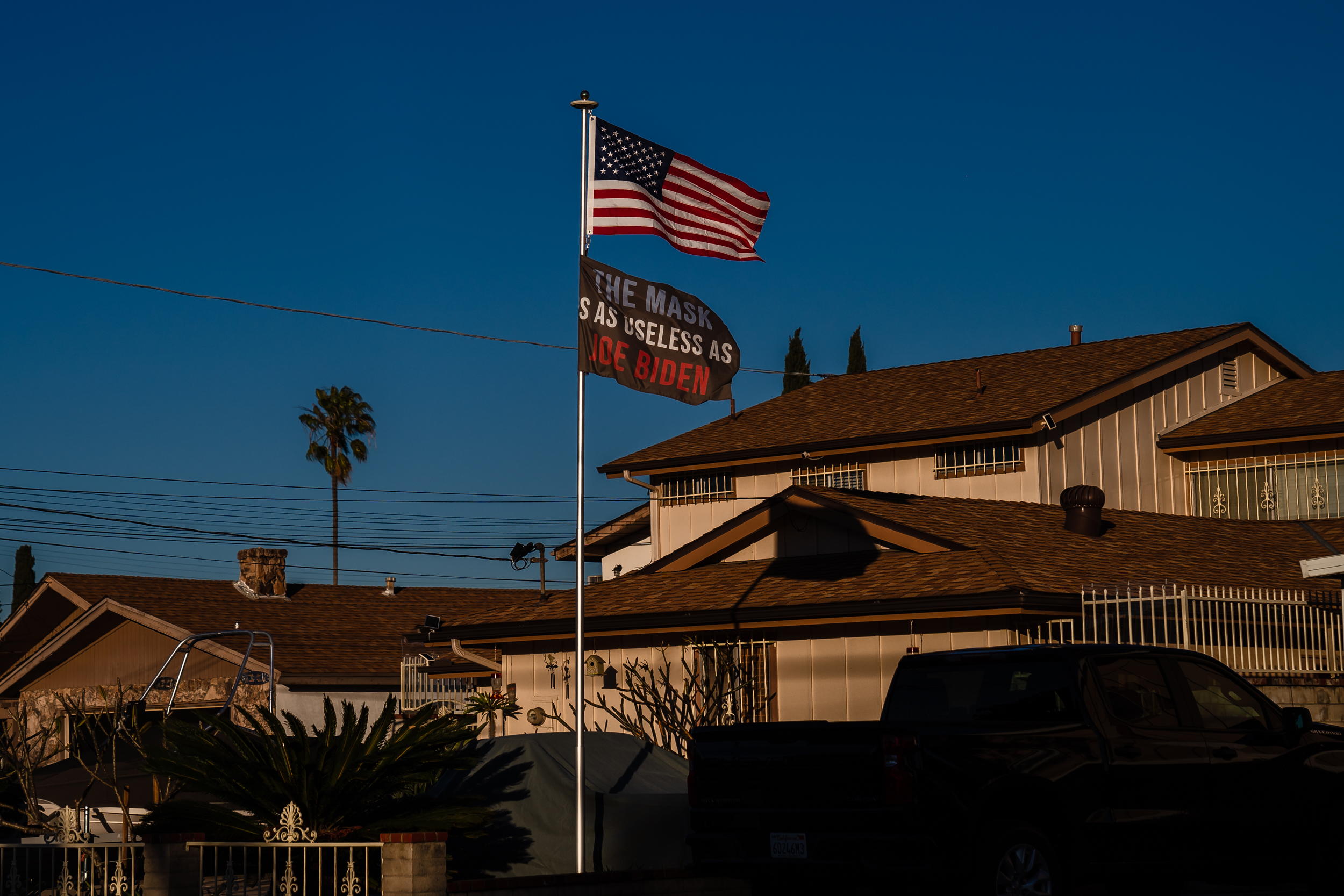 A flag reading "The Mask Is As Useless As Joe Biden" along with the American flag is seen in La Mesa on Jan 21. 2023.