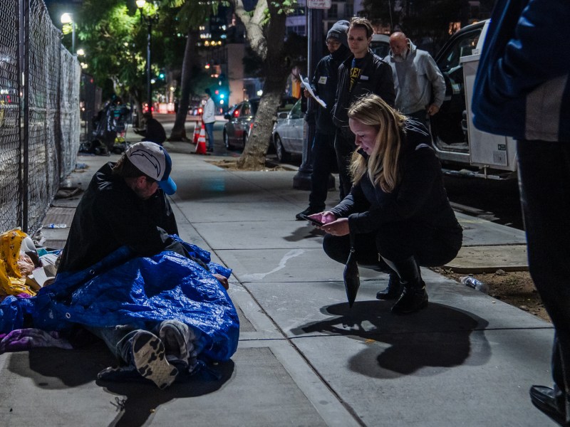 A volunteer speaks to an unhoused individual in downtown during the Point in Time Count on Jan. 26, 2023.
