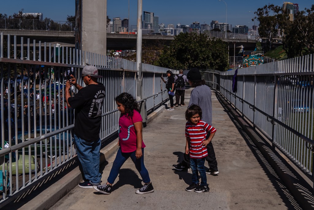 People take photos from the bridge in Barrio Logan on Chicano Park Day on April 22, 2023.