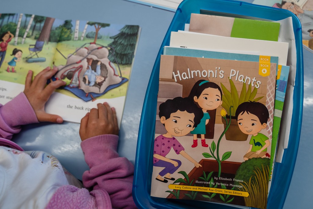 A kindergarten student listens to herself read during a class assignment at Spreckels Elementary school in University City on April 24, 2023.