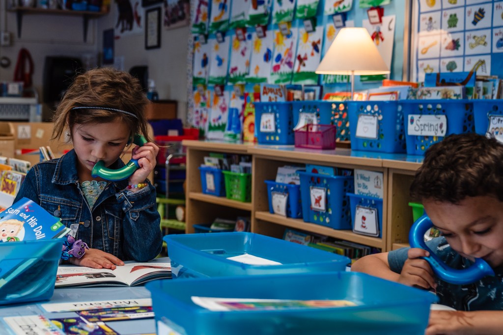 Kindergarten students listen to themselves read during a class assignment at Spreckels Elementary school in University City on April 24, 2023.