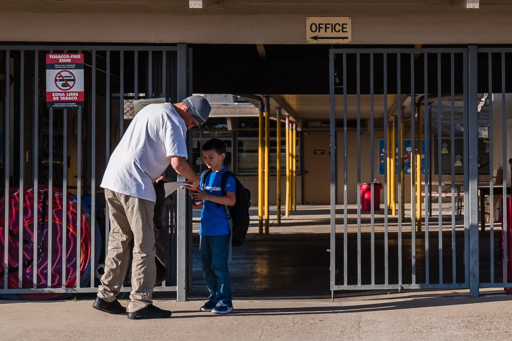 Jared Goossens picks up his son Everest from an after school program at Hardy Elementary School in the College area on April 5, 2023.