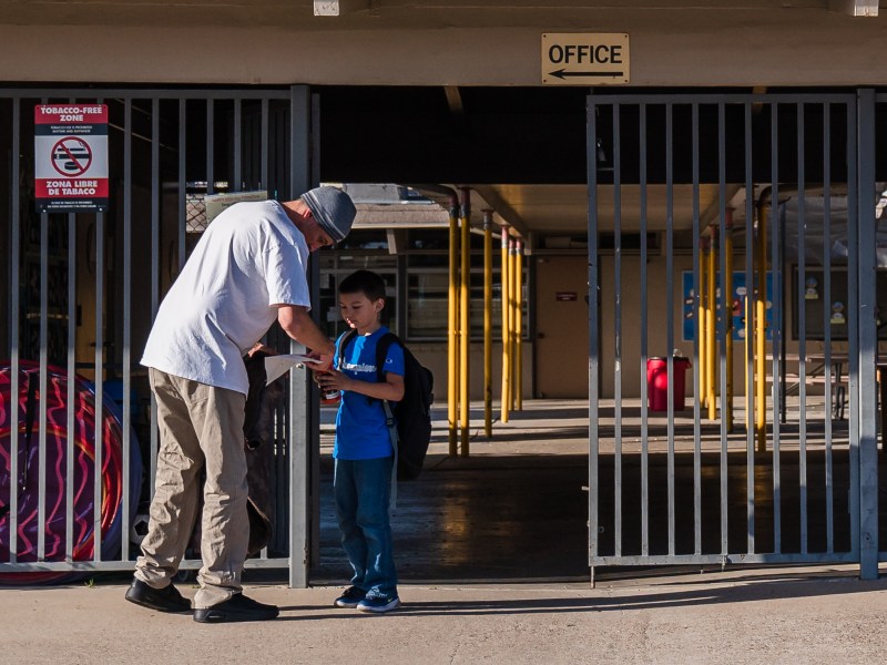 Jared Goossens picks up his son Everest from an after school program at Hardy Elementary School in the College area on April 5, 2023.