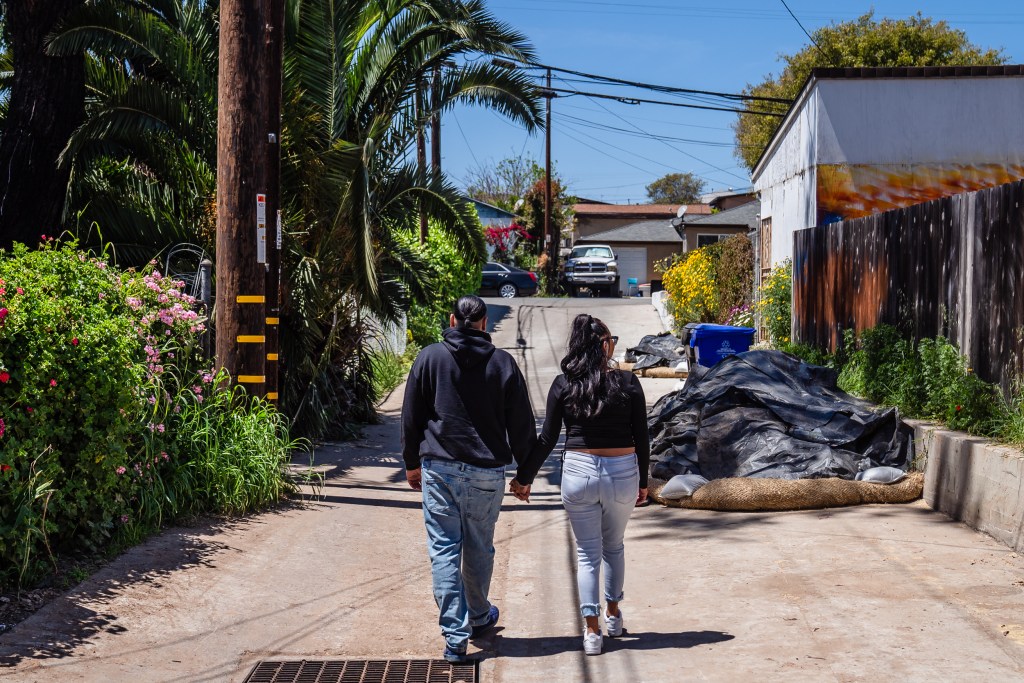 Cesar Tellez and his girlfriend Melissa Begay walk in the alley near their home they rented in the neighborhood of Mountain View on Thursday, April 20, 2023.