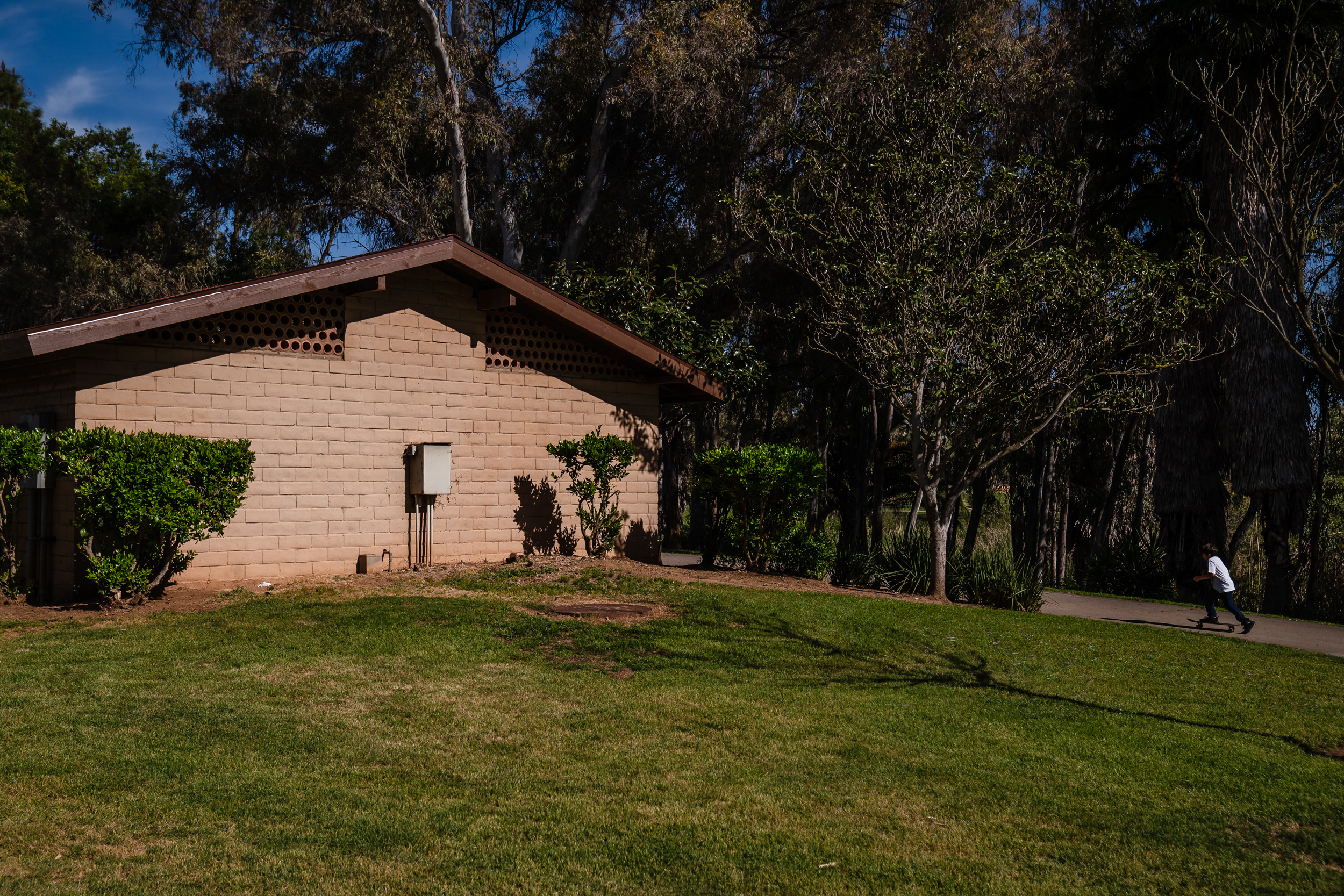 A kid skateboards near the bathrooms at Kit Carson Park in Escondido on April 20, 2023.