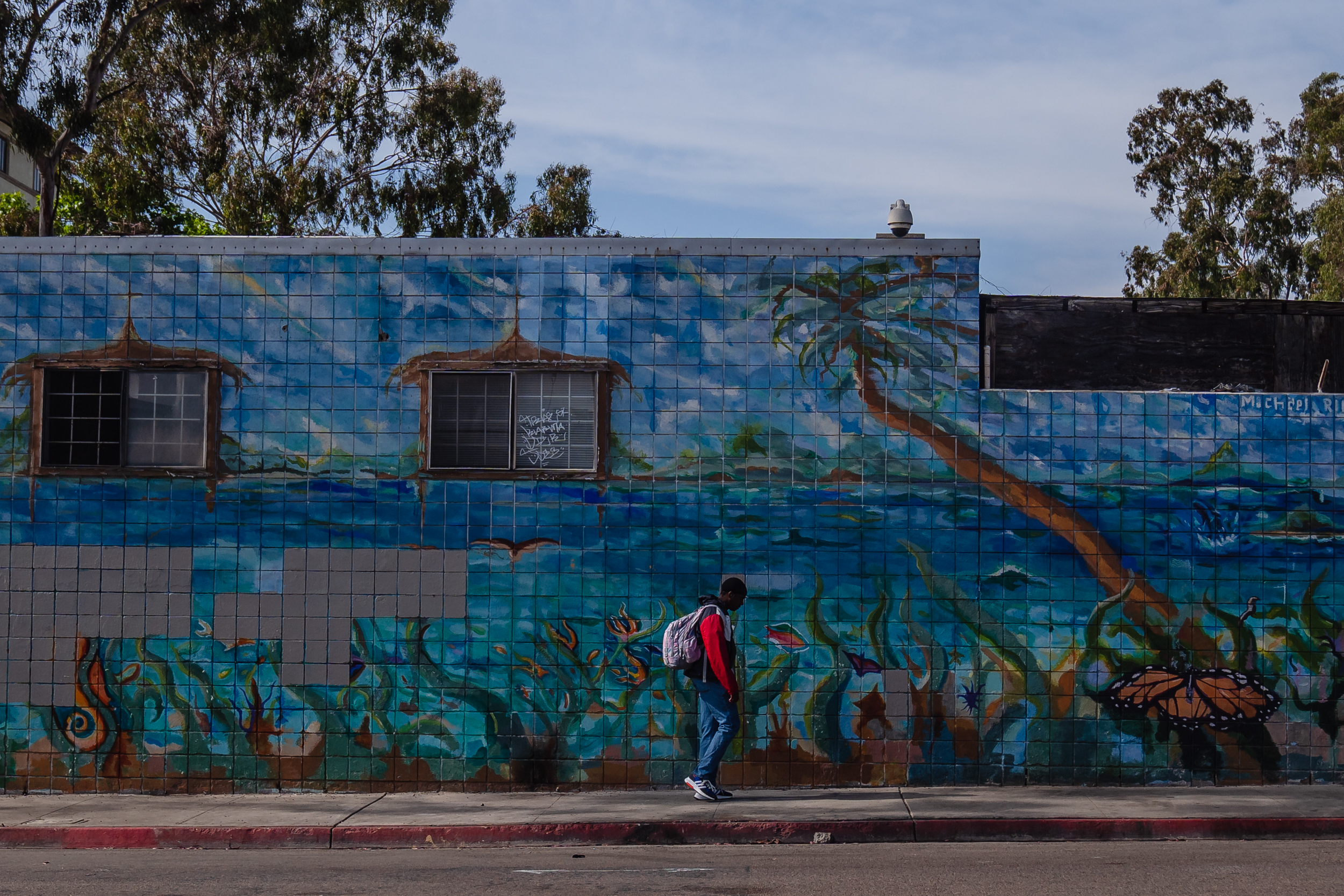 A man walks past a mural on Commercial Street in downtown on May 18, 2023.