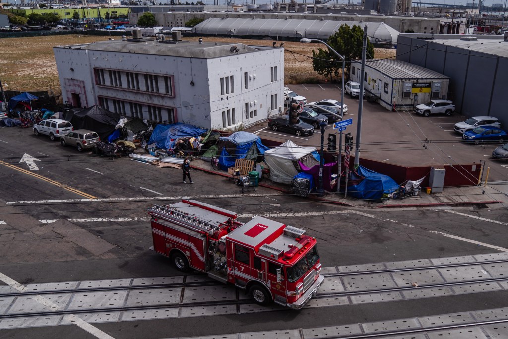 A firetruck passes a homeless encampment on National Avenue in the East Village on May 19, 2023.