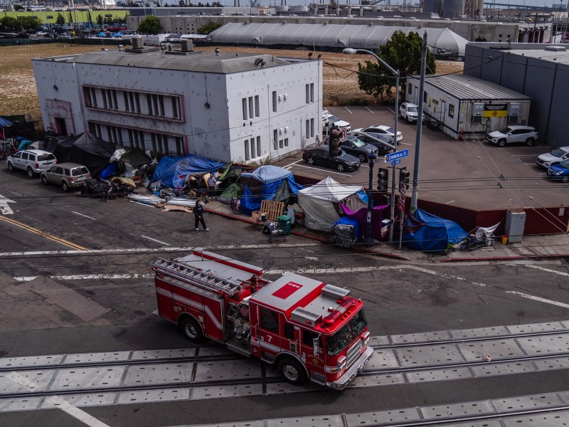 A firetruck passes a homeless encampment on National Avenue in the East Village on May 19, 2023.